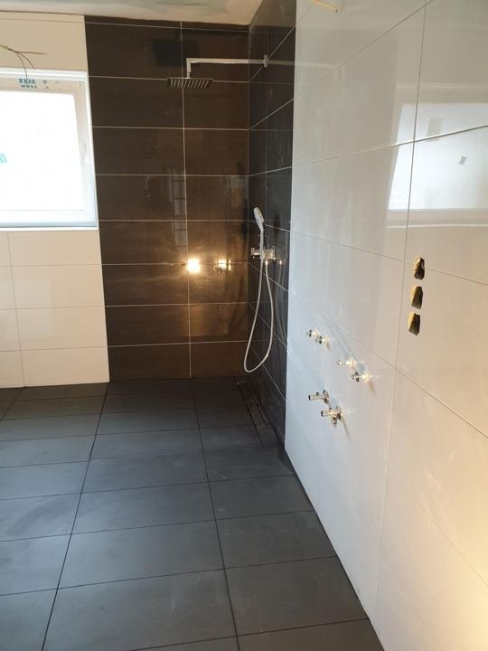 Walk-in-Dusche mit dunkler Rückwand und Duschrinne