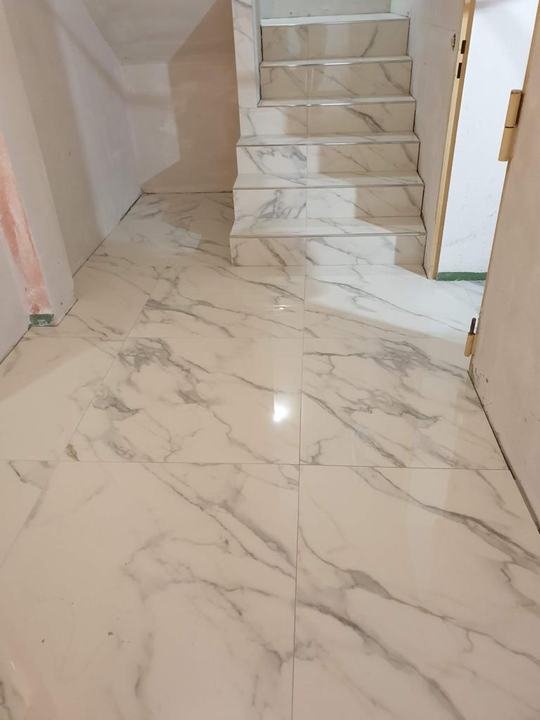 Flur mit Treppe in Calacatta-Optik